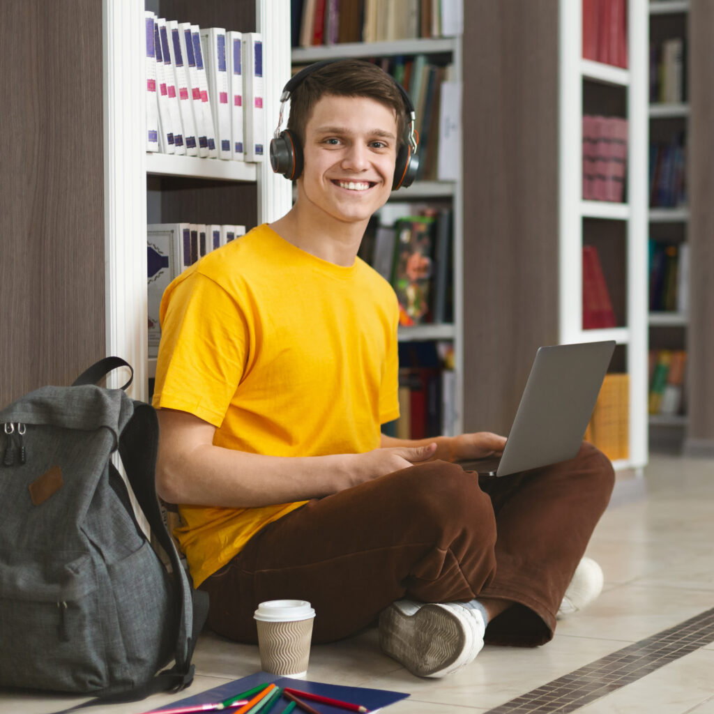 Portrait of cheerful student working on new project at library